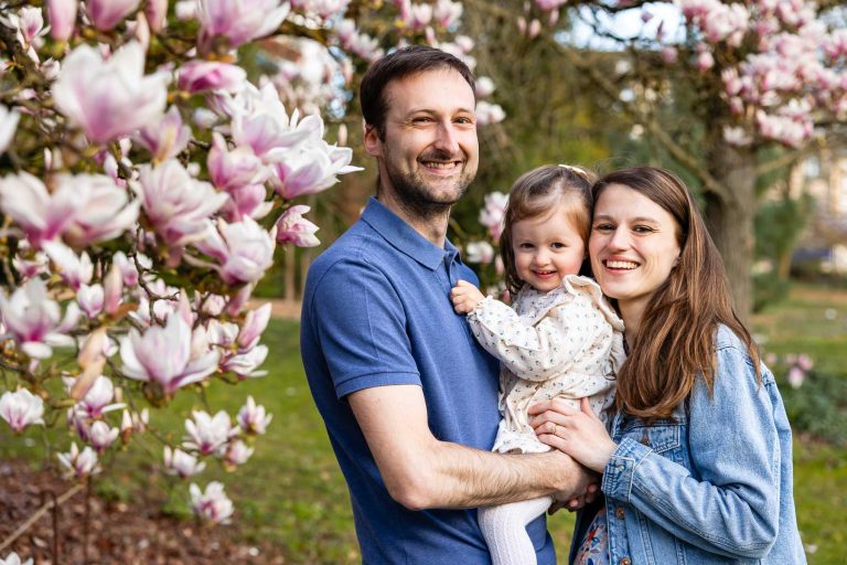 portrait d'un papa, une maman et leur fille dans le magnolia en fleurs au jardin botanique de metz