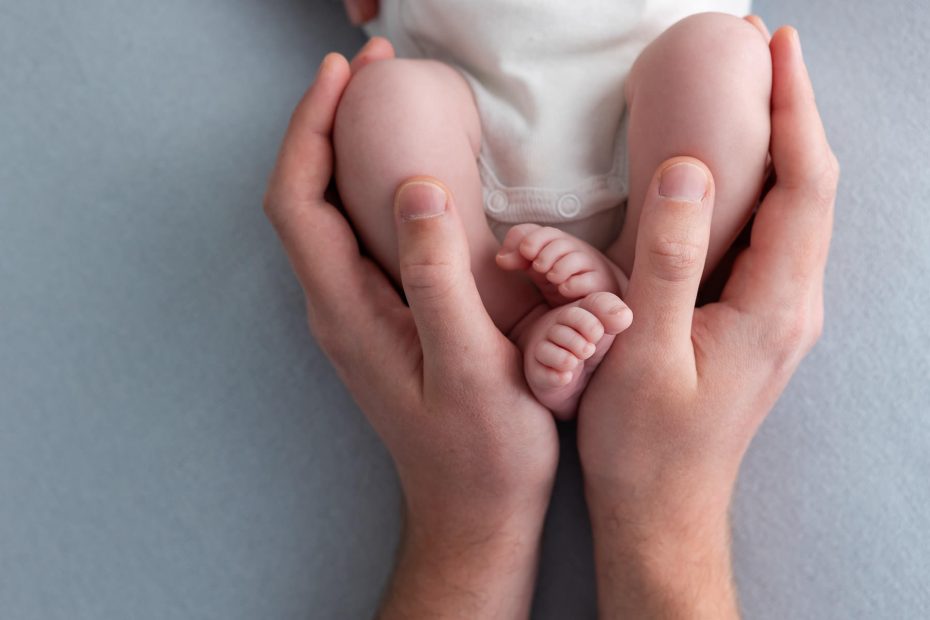 photo de pieds de bébé dans les mains du papa