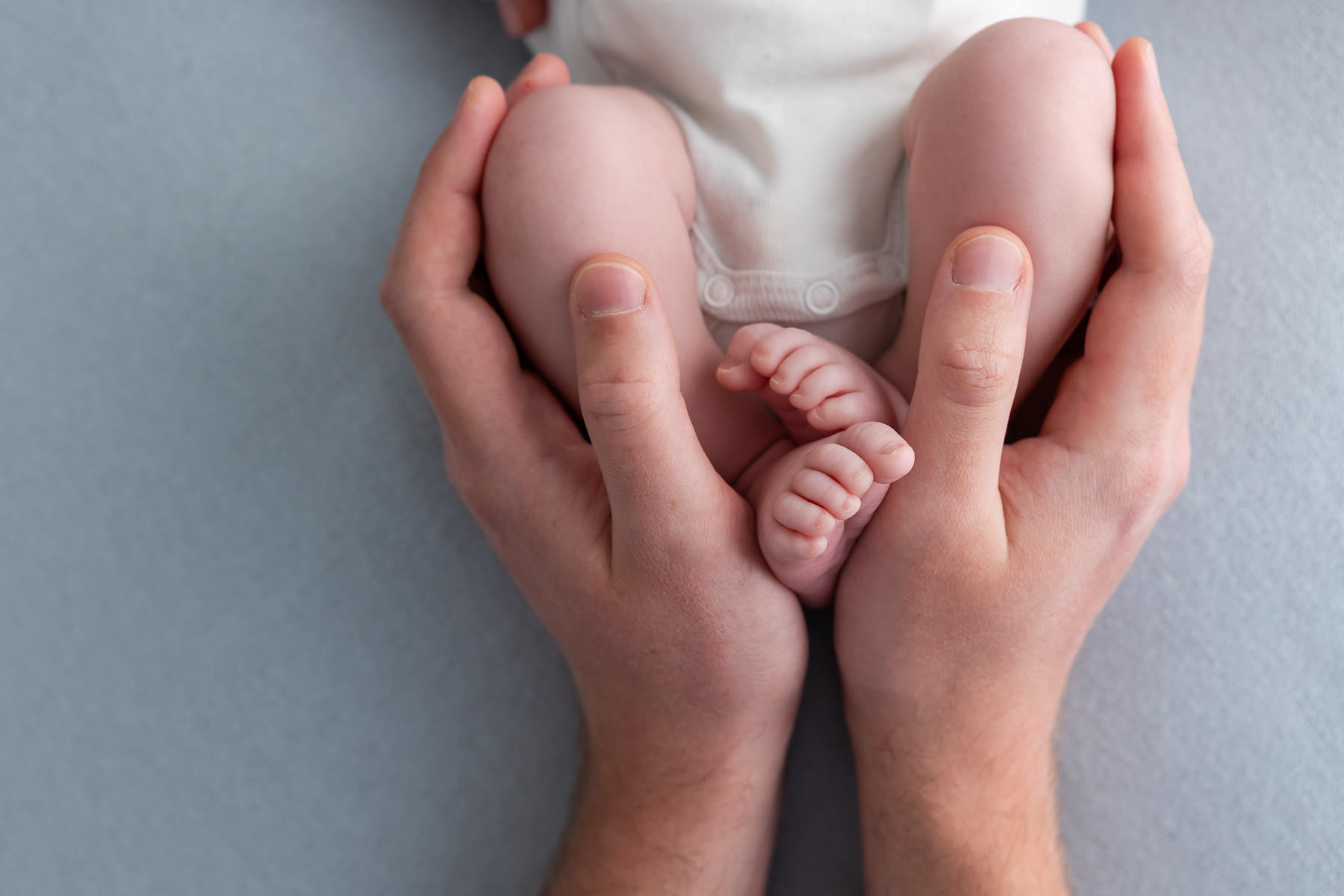 photo de pieds de bébé dans les mains du papa