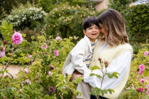portrait d'une maman et son petit garçon faisant un câlin au milieu de la roseraie du jardin botanique